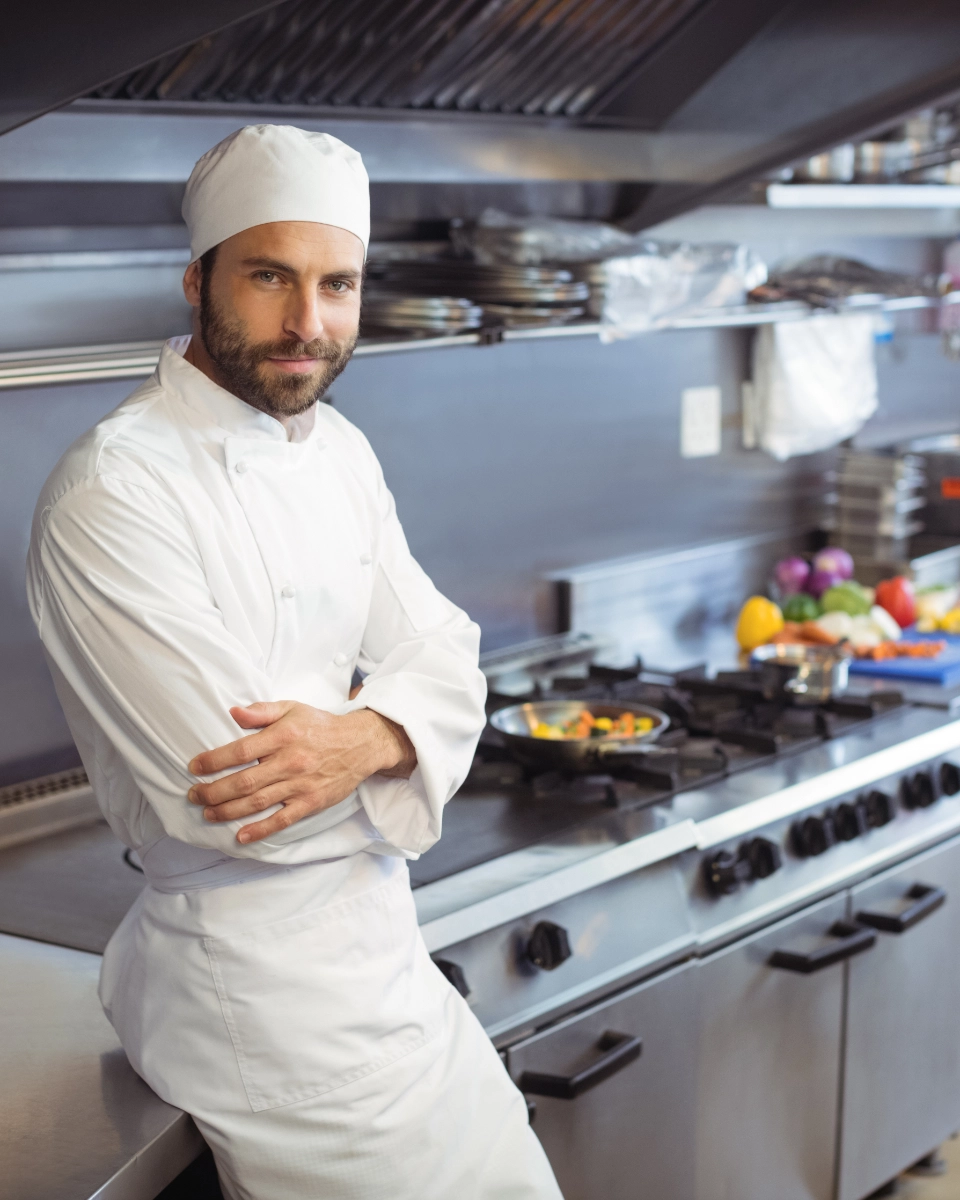 Professional cook in white uniform inside the industrial kitchen of a US hotel after his LOORU placement
